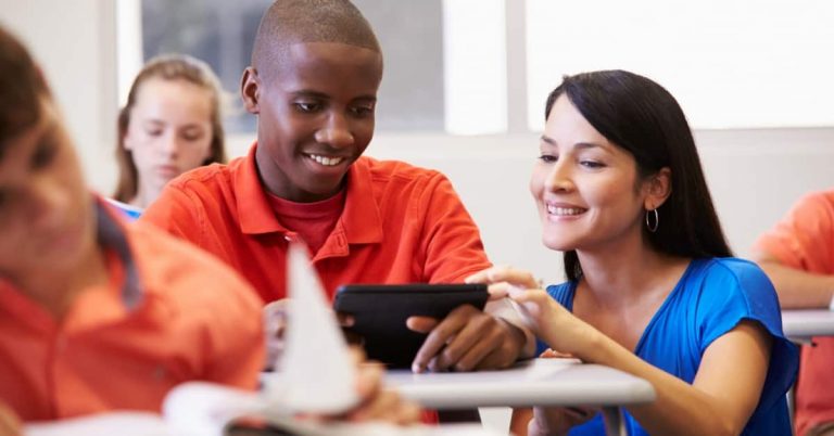 Teacher helping male student in the classroom