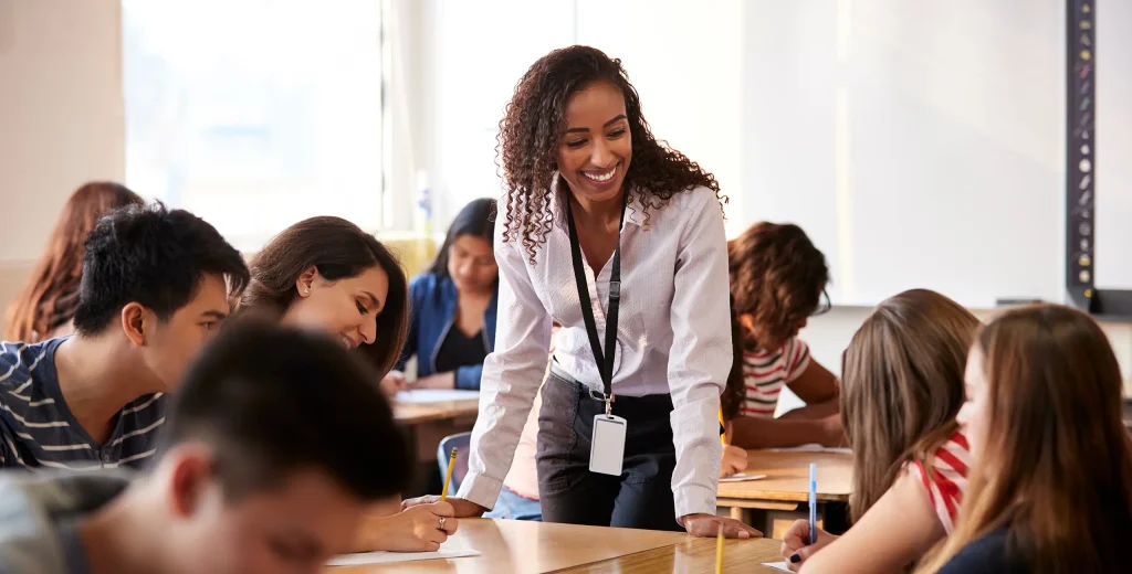 Female AP teacher smiling at students in the classroom.