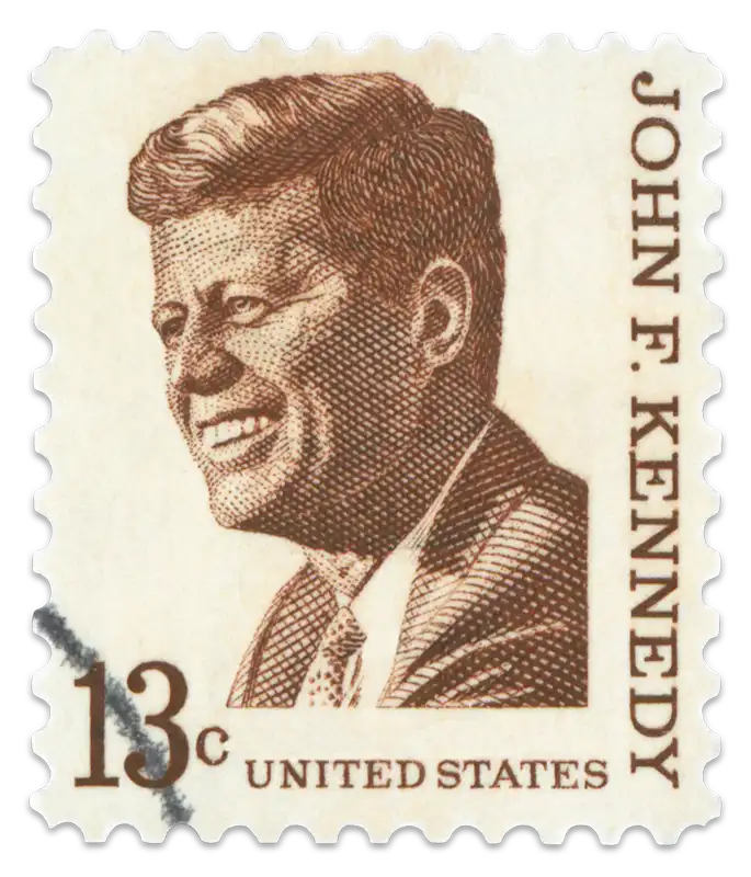 A vintage stamp with a sketched portrait of former President John F. Kennedy.