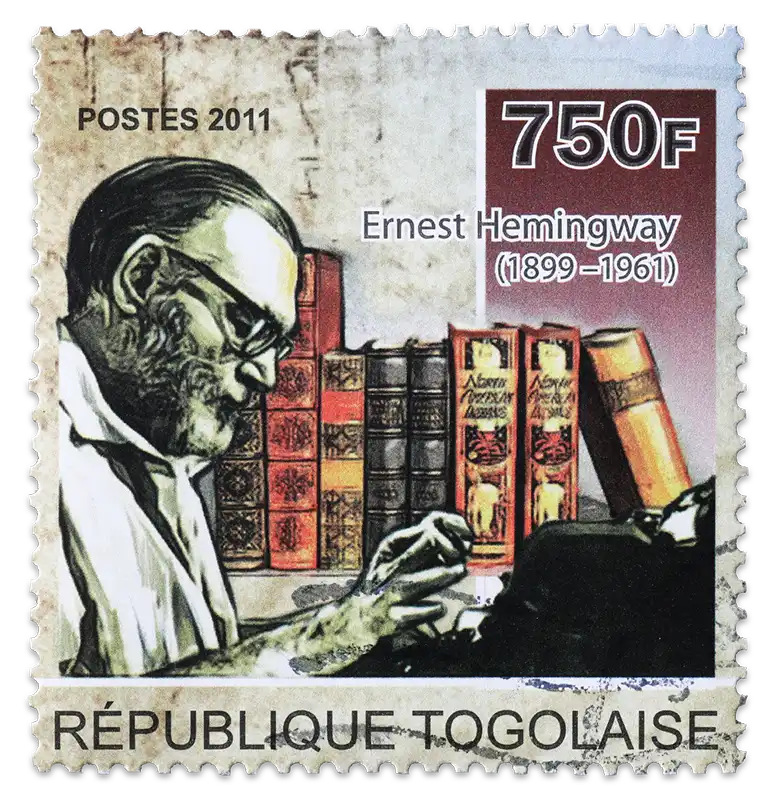 A vintage stamp with a depiction of Ernest Hemingway writing on a typewriter in front of a collection of books.