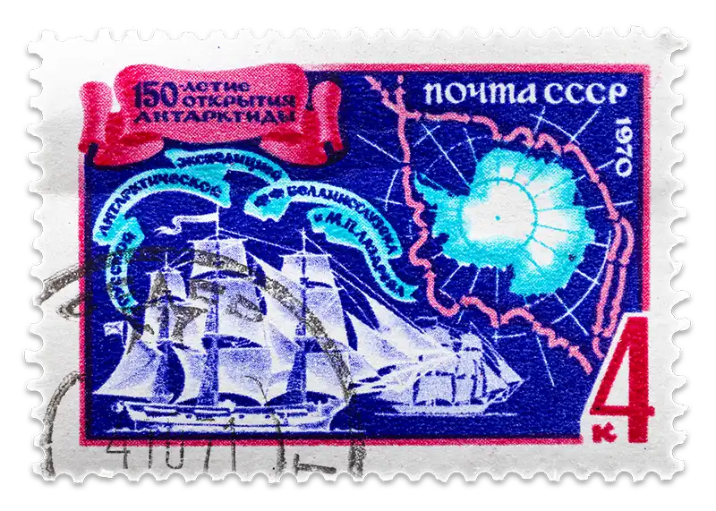 A blue and red vintage stamp depicts a map with a fleet of old ships sailing toward Antarctica.