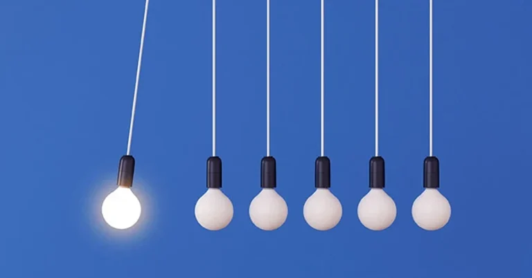 A mock up of hanging light bulbs with one glowing on a blue wall background swings like a conceptual idea of a pendulum.