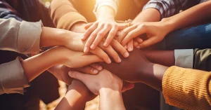 A group of people stack their hands together in a sign of teamwork.