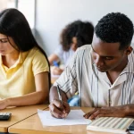 Two high-school students sit at their desks, taking an exam.